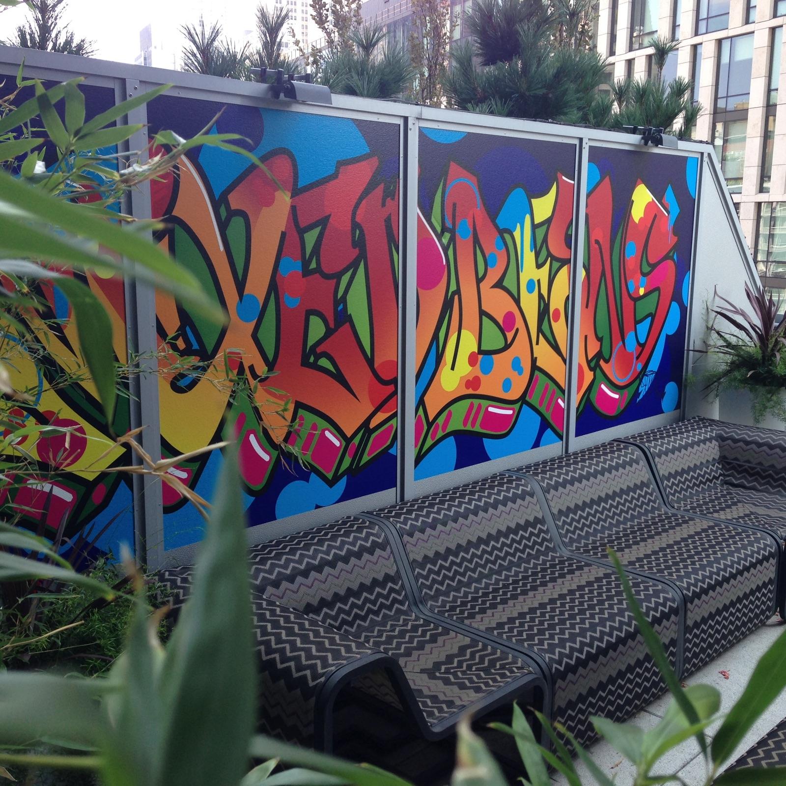 An outdoor space with a couch and a graffiti wall
