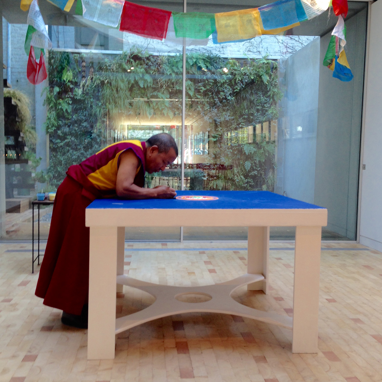 A person leaning over a blue table